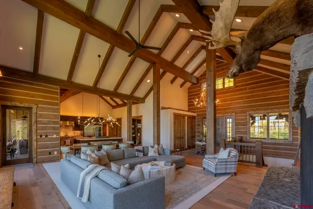 a living room with furniture a fireplace and a chandelier