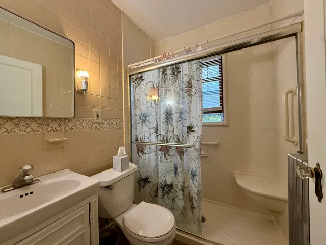 a bathroom with a sink mirror toilet and shower