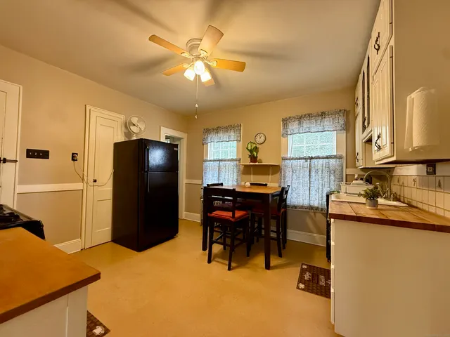 a kitchen with a refrigerator and a dining table