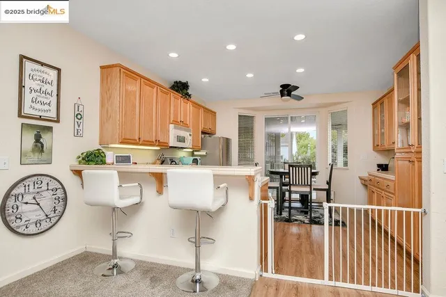 a living room with kitchen island furniture a chandelier and a large window