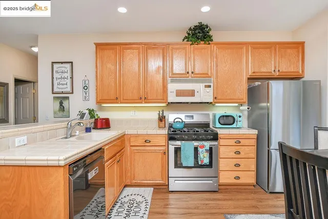 a kitchen with a dining table chairs refrigerator and cabinets