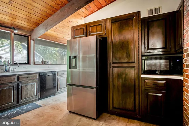 a metallic refrigerator freezer sitting inside of a kitchen
