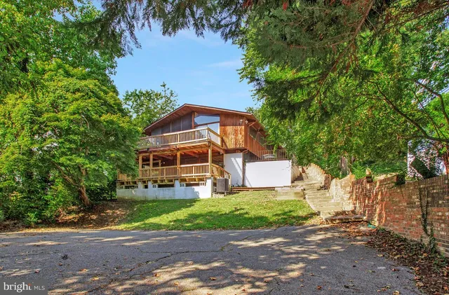 an aerial view of a house with swimming pool and trees