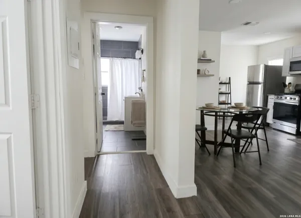 a view of a hallway to kitchen and dining room with wooden floor