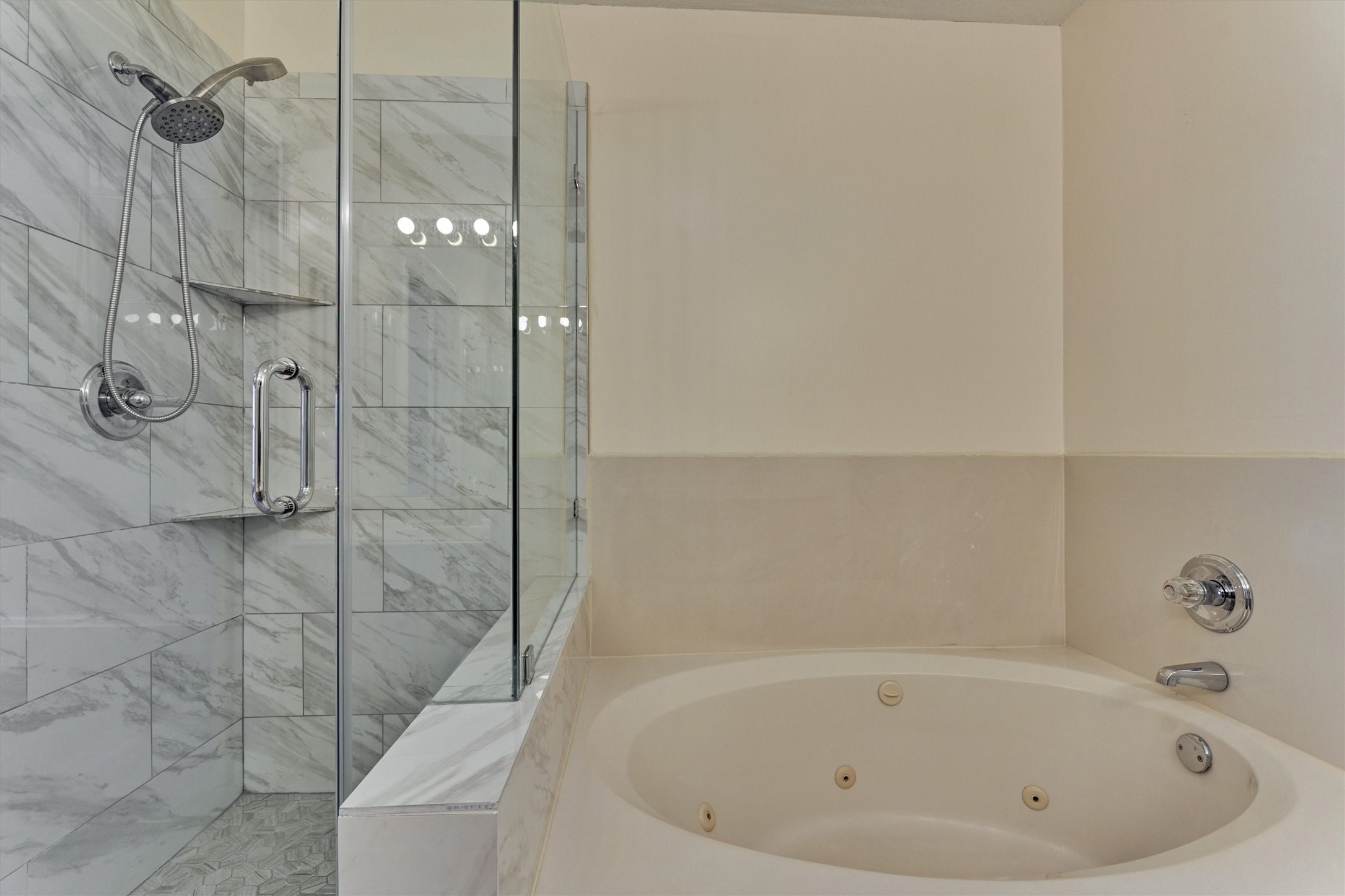 14420 Walters Road, Unit 26 Houston, TX 77014 - Photo 32 of 45 This bathroom features a modern design with a glass-enclosed shower showcasing elegant marble tiles and a spacious whirlpool tub for relaxation.