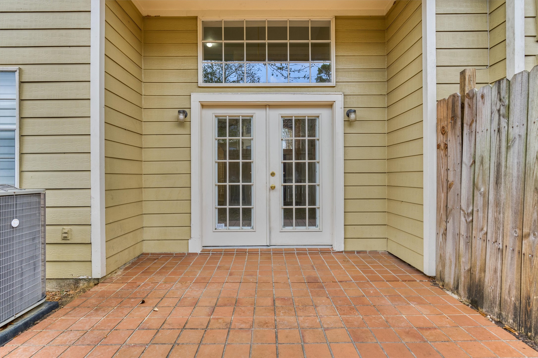 14420 Walters Road, Unit 26 Houston, TX 77014 - Photo 43 of 45 This photo shows the back patio area with terracotta tiles and a set of French doors leading inside. Note the overhead transom window for added light.