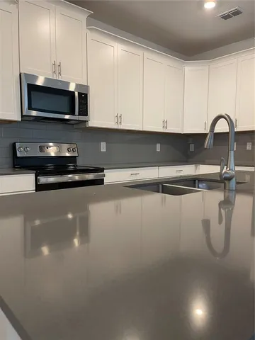 a kitchen with a sink a microwave and cabinets