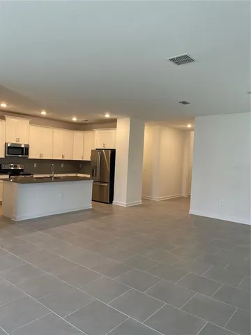 a view of an empty room with a kitchen