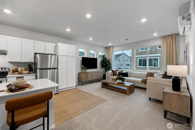 a living room with furniture kitchen view and a large window