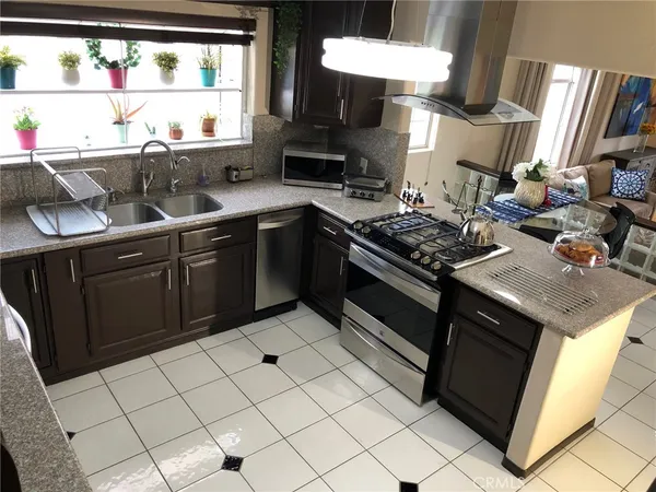 a kitchen with stainless steel appliances granite countertop a stove a sink and a microwave