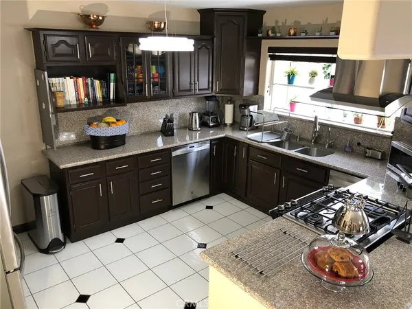 a kitchen with stainless steel appliances kitchen island granite countertop a sink stove and cabinets