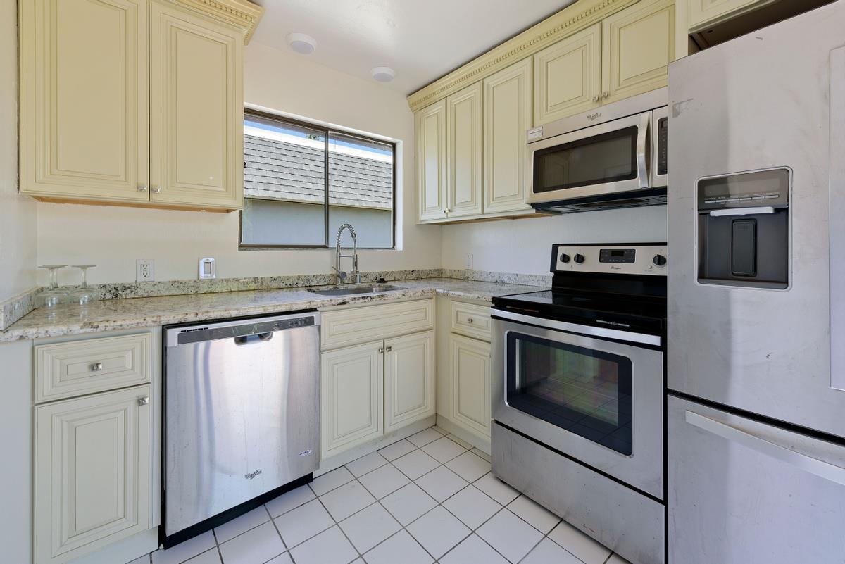 41 15th Avenue San Mateo, CA 94402 - Photo 5 of 11 a kitchen with stainless steel appliances granite countertop white cabinets a sink a stove a microwave and wooden floors