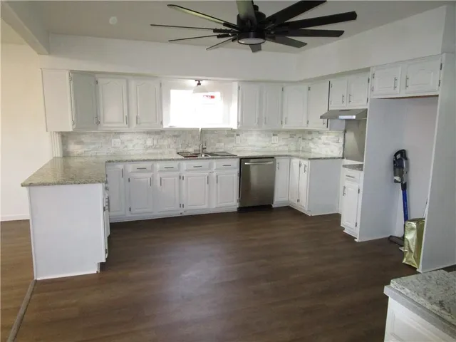 a kitchen with granite countertop cabinets stainless steel appliances a sink and a counter top space