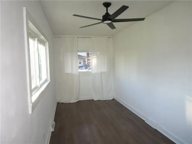 a view of a hallway with white wooden cabinets