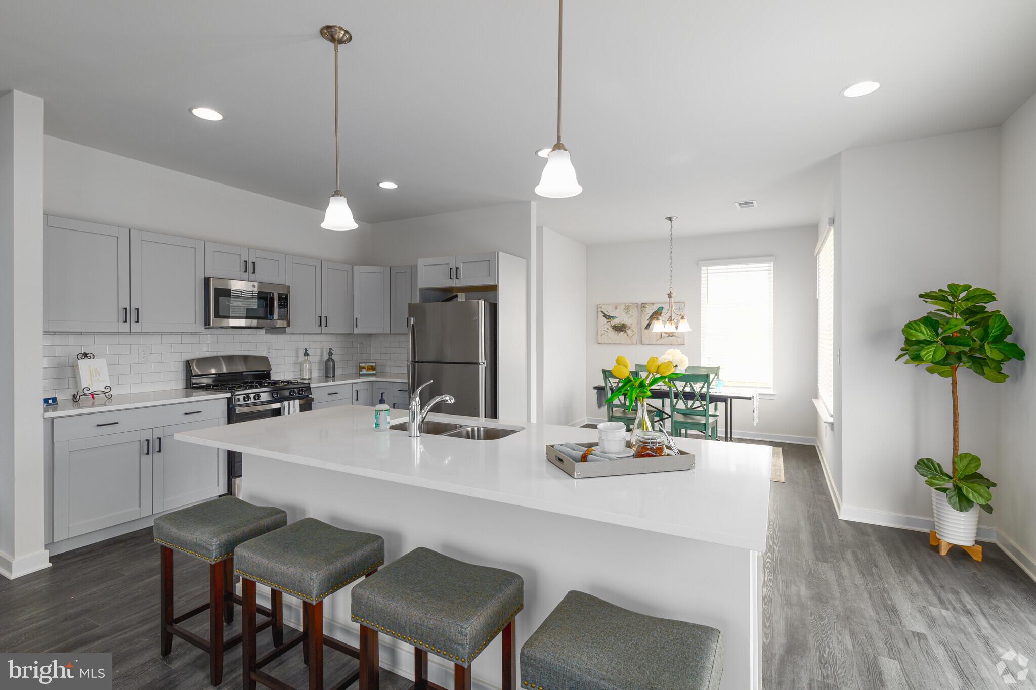 541 Ruth Way Dover, DE 19904 - Photo 2 of 10 a kitchen with sink a refrigerator and chairs