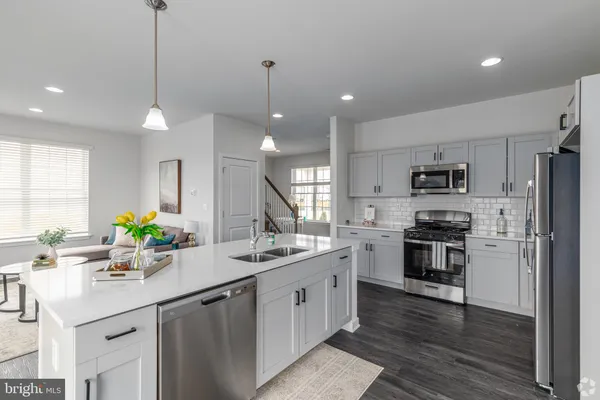 a kitchen with stainless steel appliances kitchen island a sink refrigerator and microwave