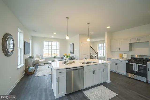 a view of a kitchen counter space a sink stainless steel appliances and wooden floor