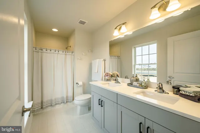 a bathroom with double vanity sinks a mirror and a shower