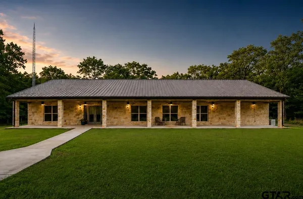 a front view of a house with a yard and trees