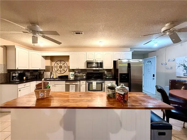 a kitchen with kitchen island granite countertop a sink counter top space and stainless steel appliances