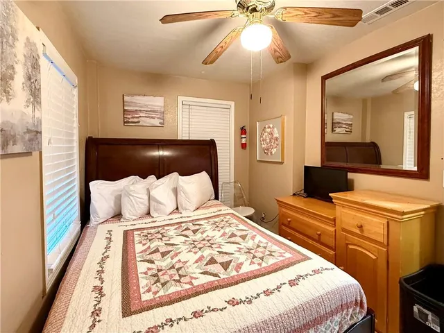 a bedroom with a large bed and a chandelier