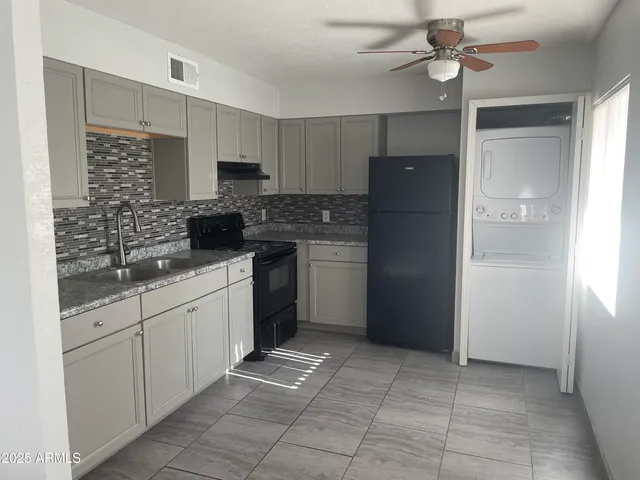 a kitchen with stainless steel appliances granite countertop a refrigerator and a sink