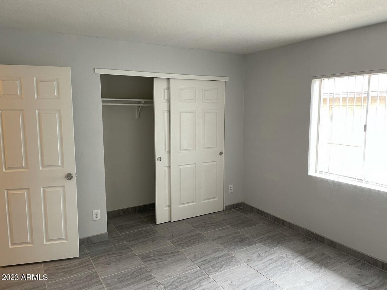 1222 East Mountain View Road, Unit 208 Phoenix, AZ 85020 - Photo 13 of 24 an empty room with windows and closet