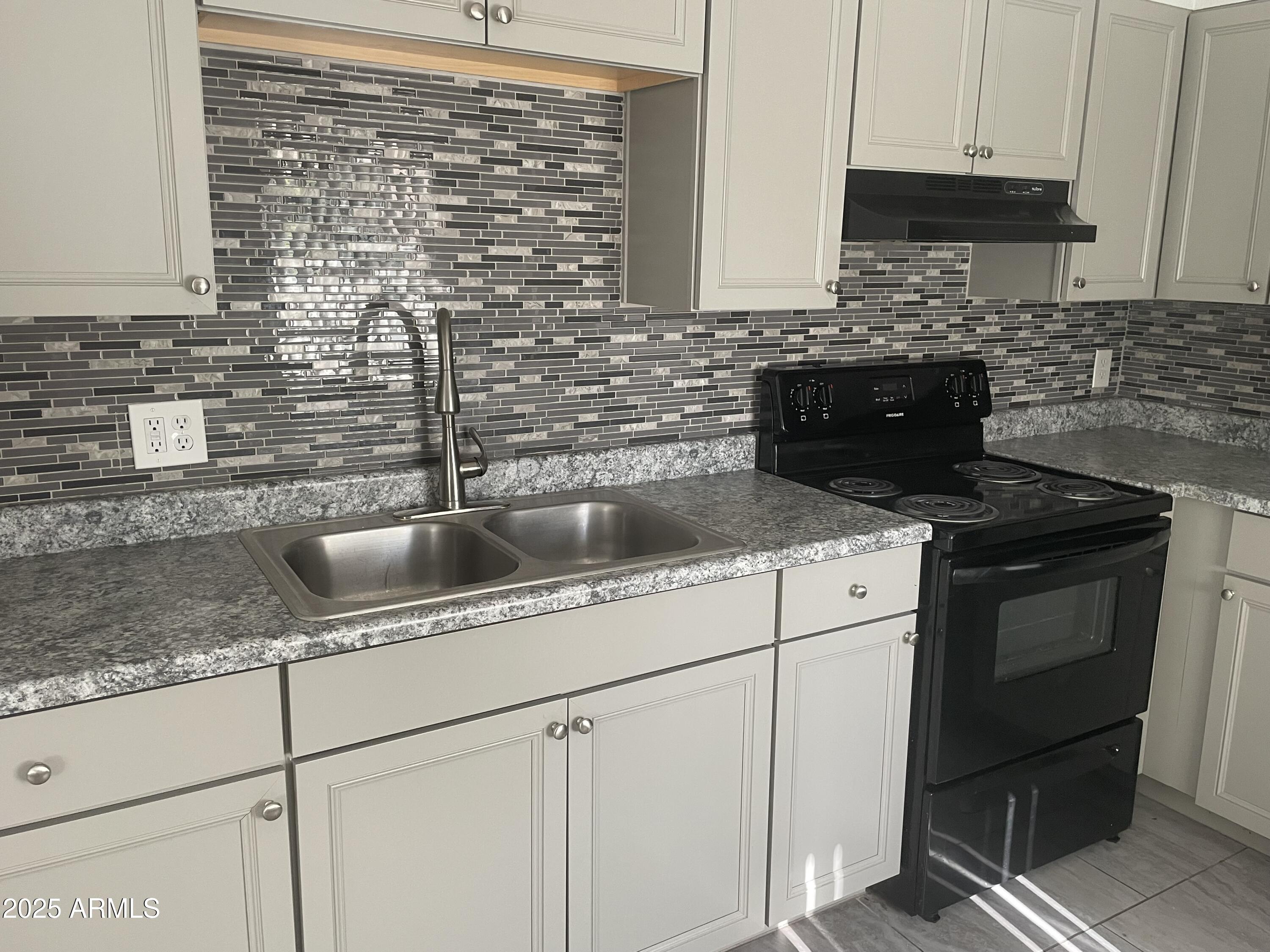 1222 East Mountain View Road, Unit 208 Phoenix, AZ 85020 - Photo 7 of 24 a kitchen with stainless steel appliances granite countertop a sink stove and cabinets