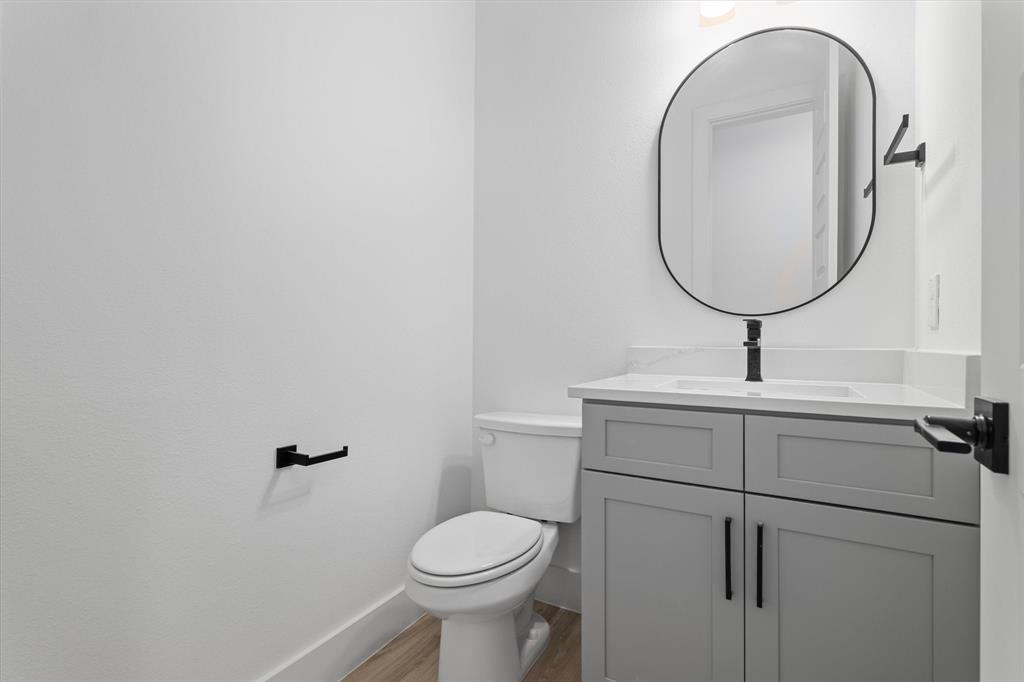 8918 Lowell Street Rowlett, TX 75089 - Photo 16 of 30 a bathroom with a toilet a sink and mirror