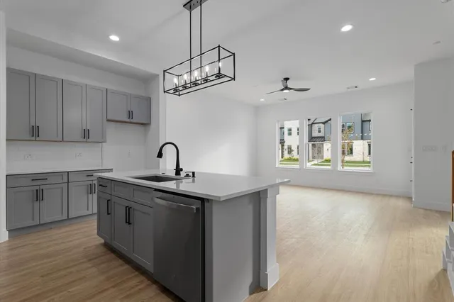 a kitchen with stainless steel appliances granite countertop a sink a stove a refrigerator and cabinets