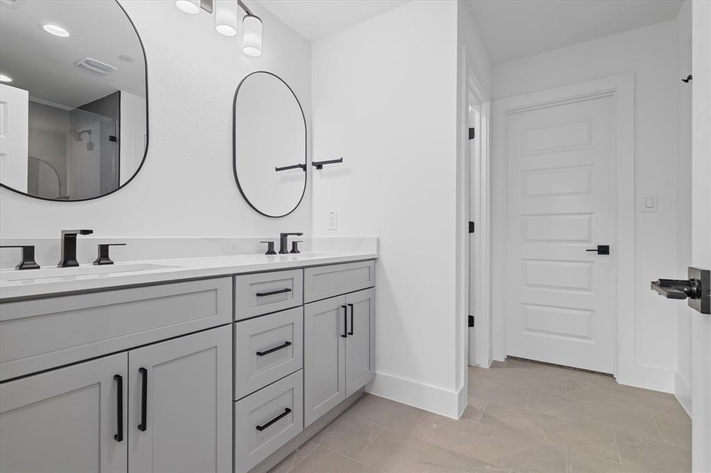 8918 Lowell Street Rowlett, TX 75089 - Photo 22 of 30 a bathroom with a double vanity sink and a mirror