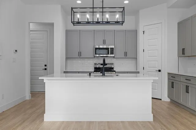 a kitchen with kitchen island white cabinets and stainless steel appliances
