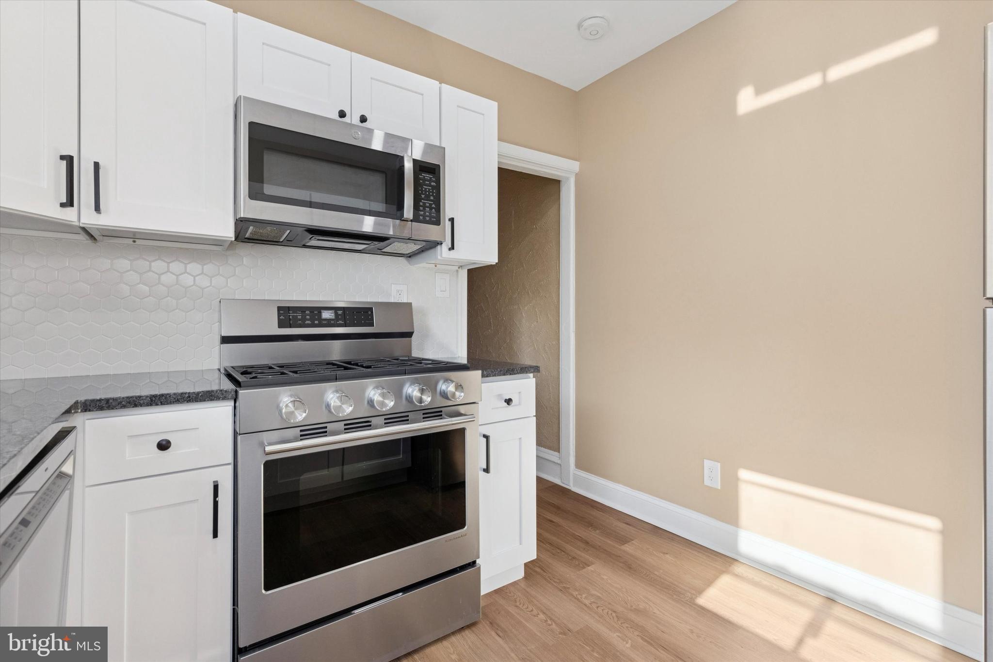 206 Ripka Street, Unit 2 Philadelphia, PA 19127 - Photo 4 of 15 a kitchen with stainless steel appliances a stove a microwave oven cabinets and a counter space