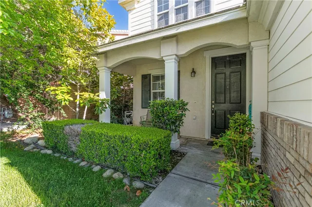 a view of a house with brick walls and a yard with plants