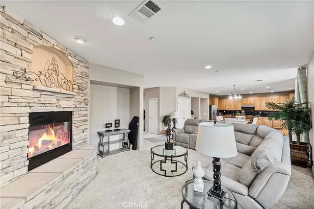 a living room with furniture a fireplace and a dining table with kitchen view