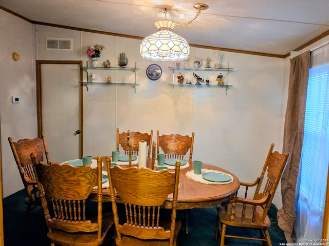 a view of a dining room with furniture and chandelier