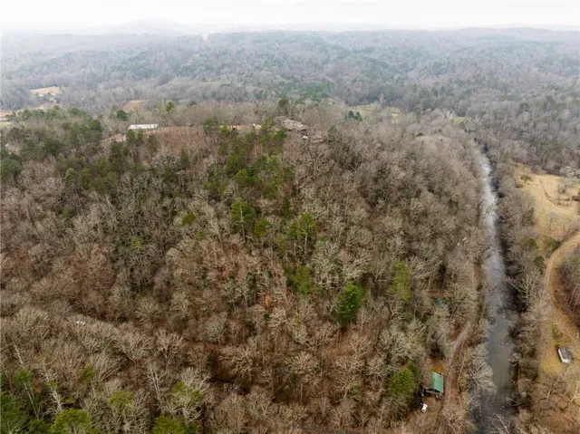 an aerial view of house with yard and mountain view in back