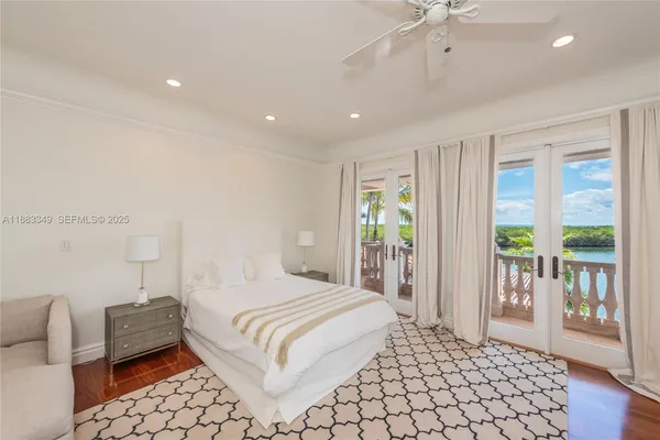 a bedroom with a bed and large windows