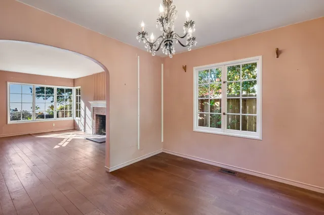 a view of a room with wooden floor and a chandelier