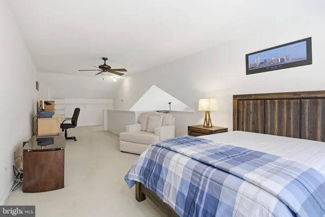 a spacious bedroom with a bed and wooden floor