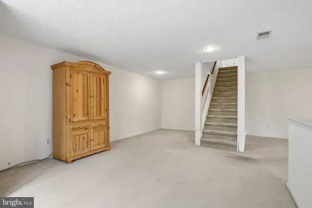 an empty room with wooden door and windows