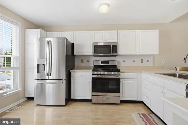 a kitchen with stainless steel appliances a refrigerator stove and microwave
