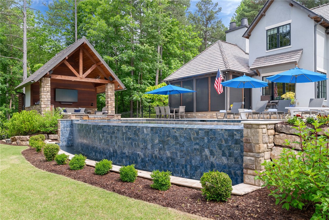119 Drewberry Lane Sunset, SC 29685 - Photo 26 of 42 An inviting backyard oasis features an infinity pool and an outdoor kitchen, perfect for entertaining.
