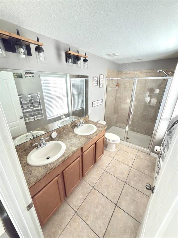 1277 Seburn Road Apopka, FL 32703 - Photo 15 of 28 a bathroom with a double vanity sink a toilet a mirror and shower