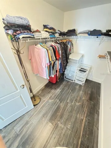 a view of walk in closet with clothes and shoes