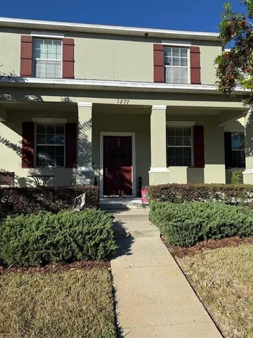 front view of a brick house with a small yard