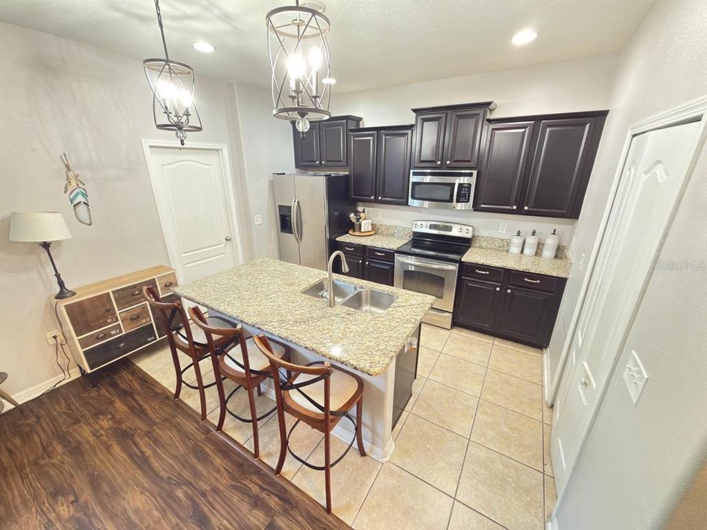 1277 Seburn Road Apopka, FL 32703 - Photo 5 of 28 a kitchen with refrigerator cabinets and wooden floor
