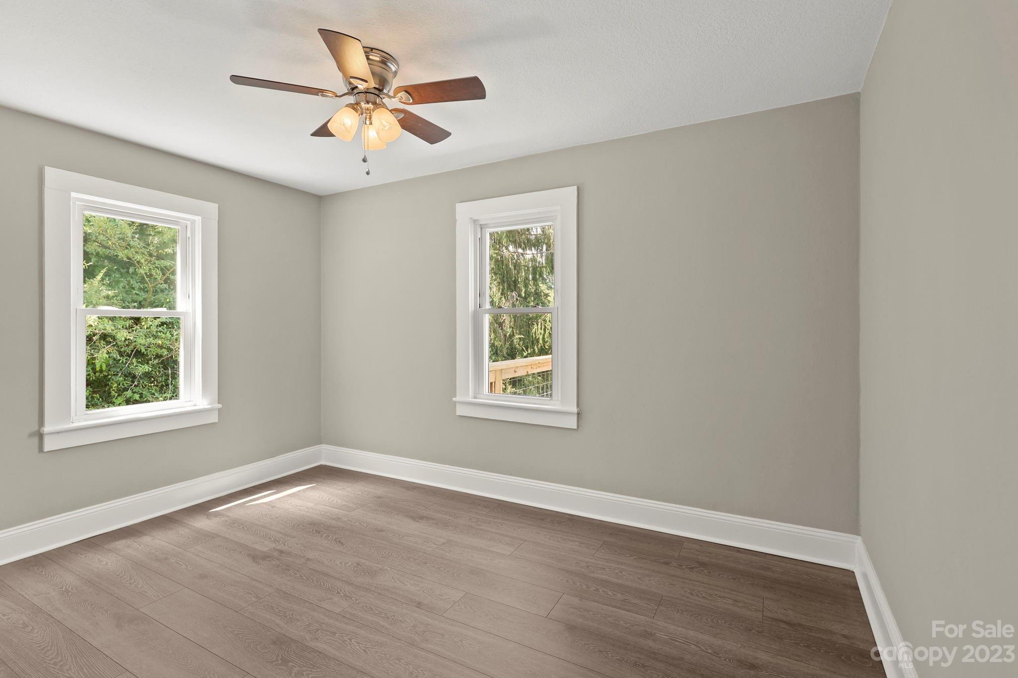 185 Substation Road Canton, NC 28716 - Photo 15 of 32 a view of an empty room with wooden floor and a window