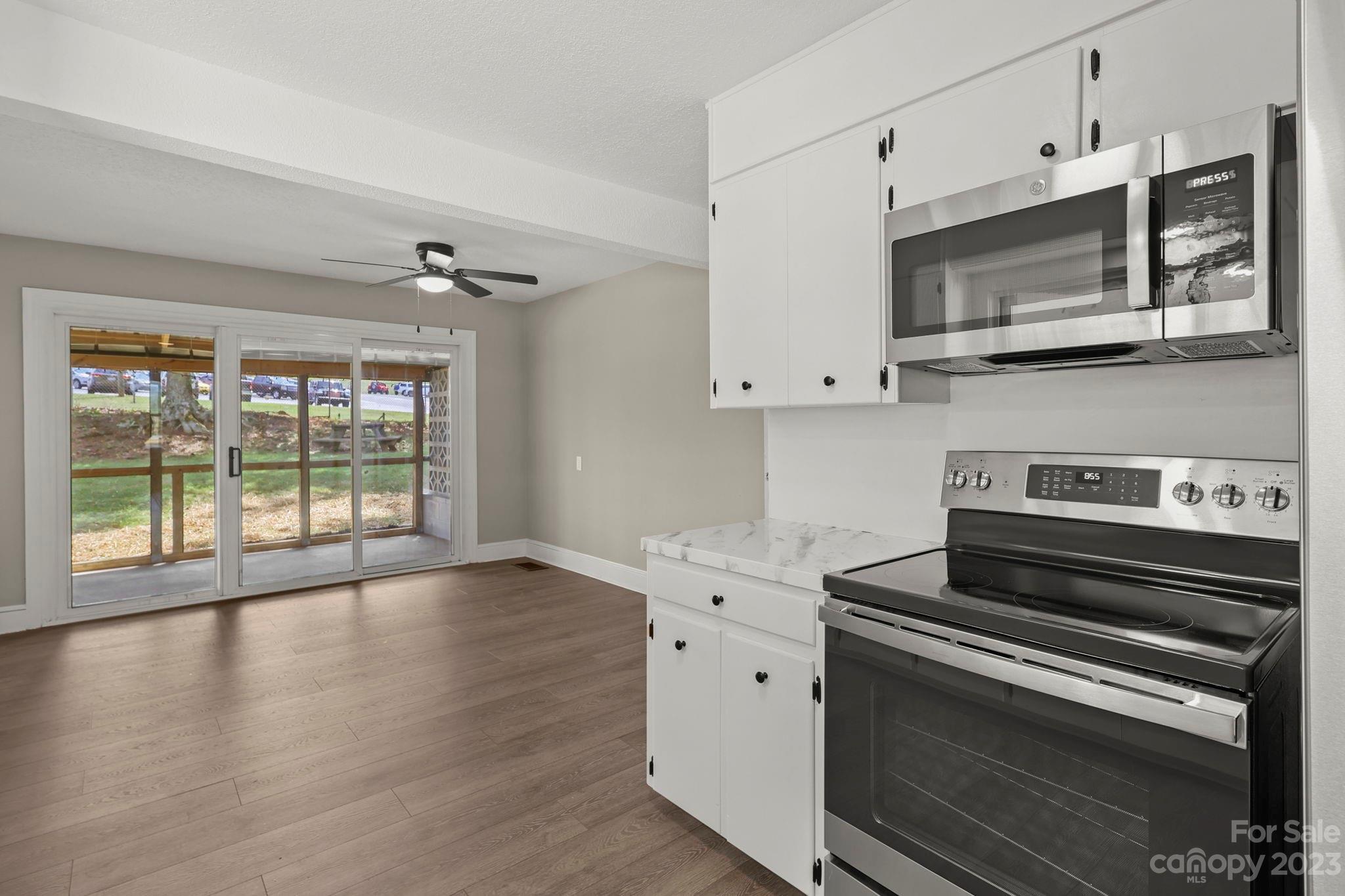 185 Substation Road Canton, NC 28716 - Photo 18 of 32 a kitchen with stainless steel appliances a stove microwave and cabinets