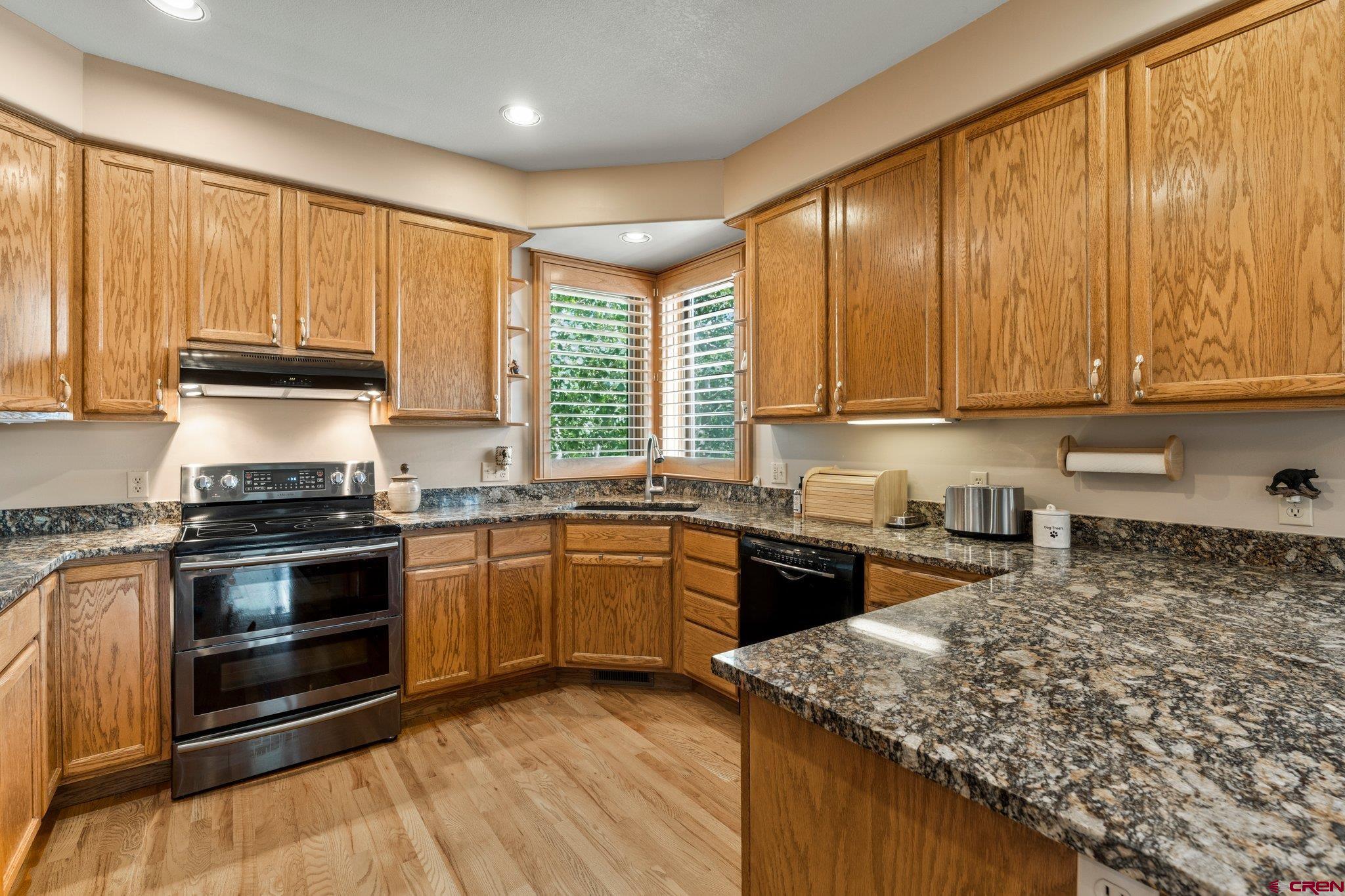 60 Edgemont Way Durango, CO 81301 - Photo 11 of 35 a kitchen with stainless steel appliances granite countertop wooden cabinets a stove and a sink